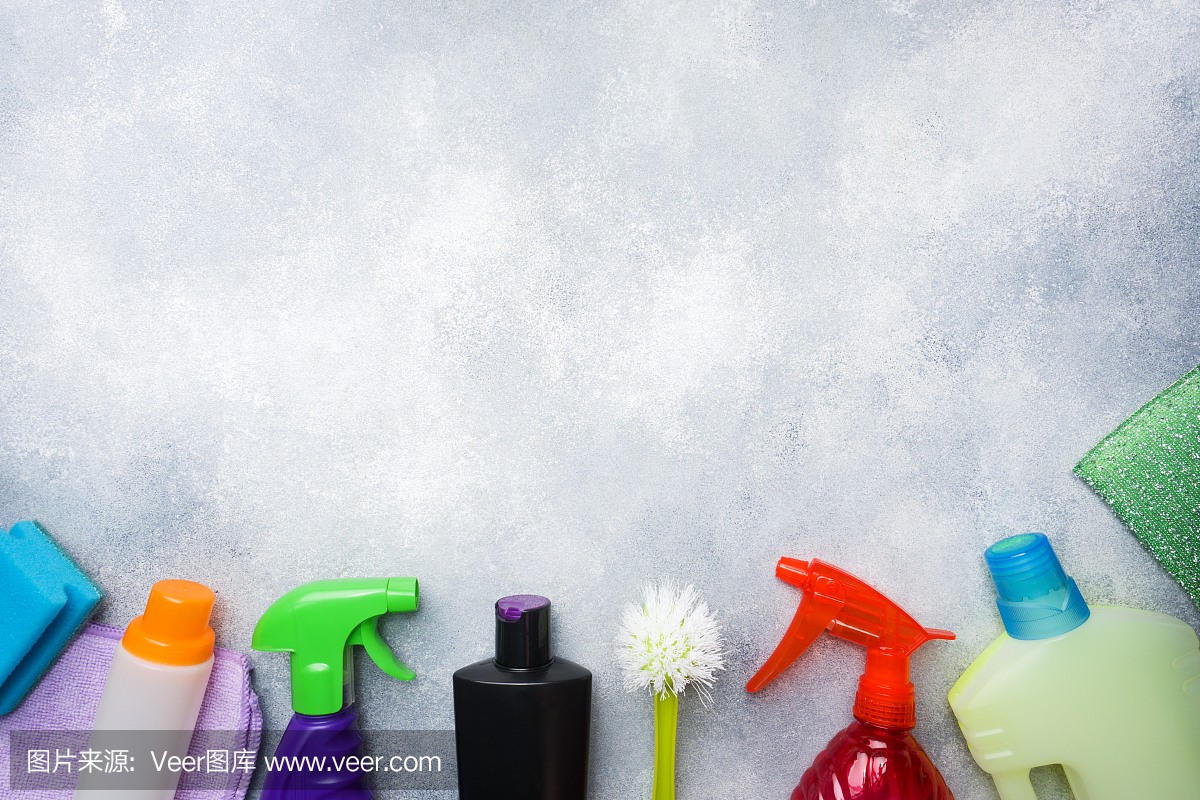 瓶子與洗滌劑,刷子和海綿在混凝土背景。色彩鮮艷的清潔產(chǎn)品。家庭清潔的概念。俯視圖,復(fù)制空間。